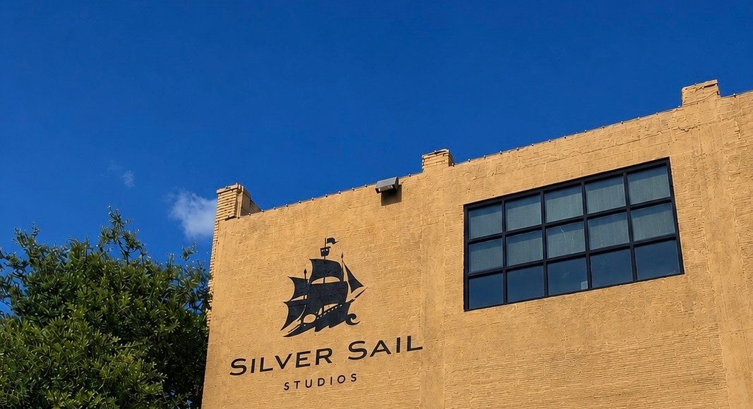 The Silver Sail Studios building exterior in Fort Worth, Texas, with the ship logo on the facade against a blue sky