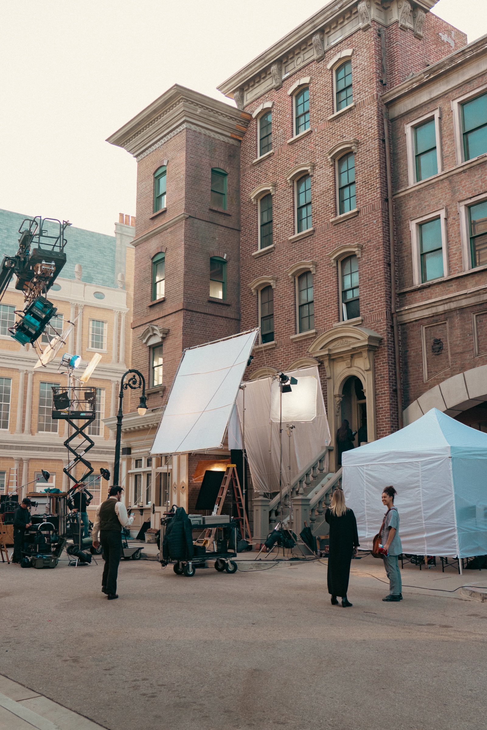 A film crew shooting on a brownstone backlot set with lighting equipment at Silver Sail Studios