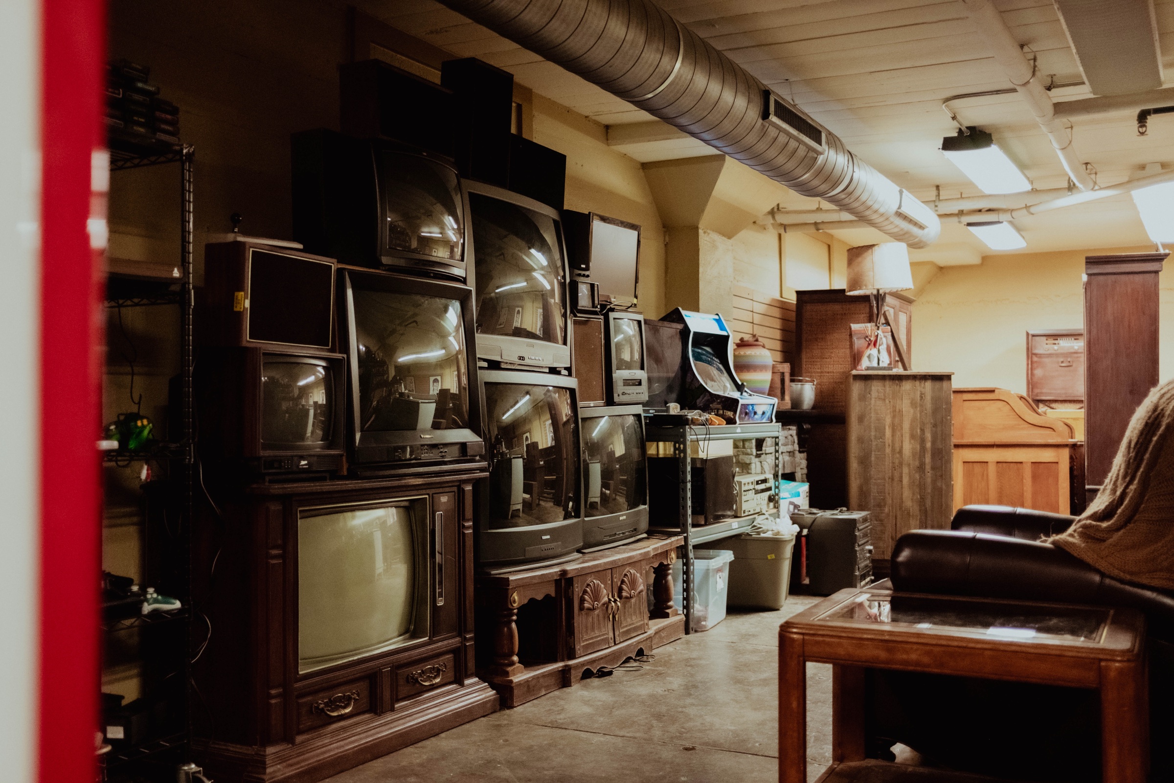 Rows of vintage CRT televisions, an arcade cabinet, and period furniture in the art department at Silver Sail Studios
