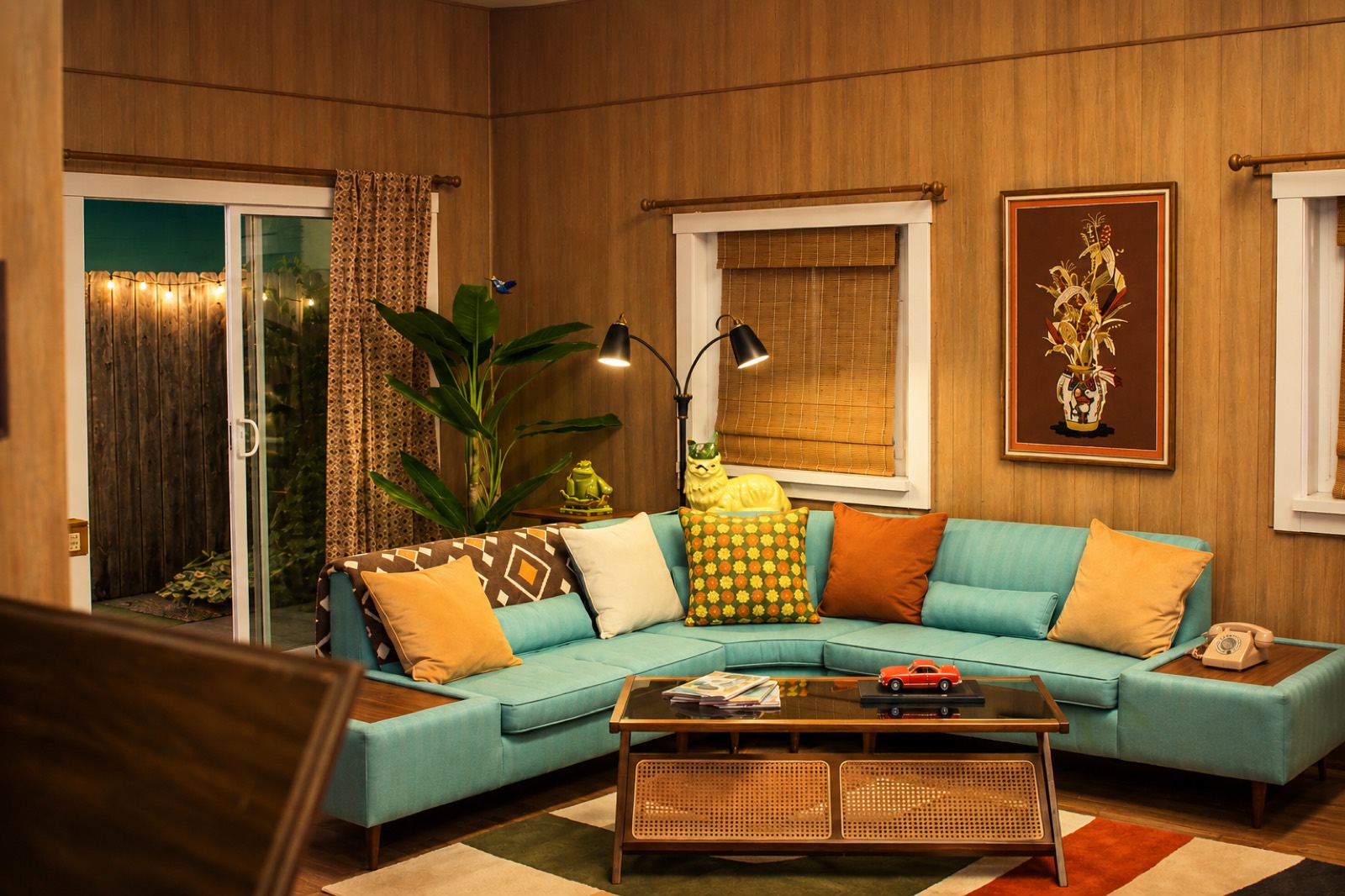 Retro wood-panel living room set with teal sectional and mid-century decor